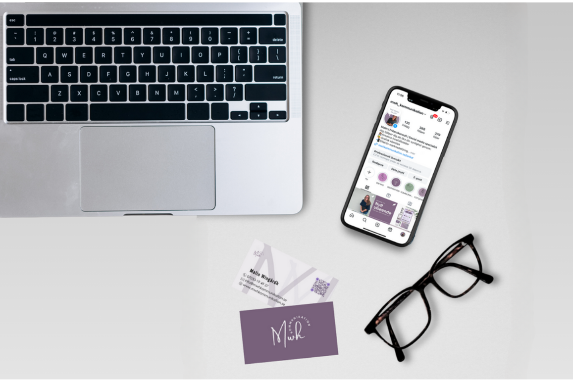 På ett bord syns en mobiltelefon, glasögon, liten del av en dator syns även i bild.