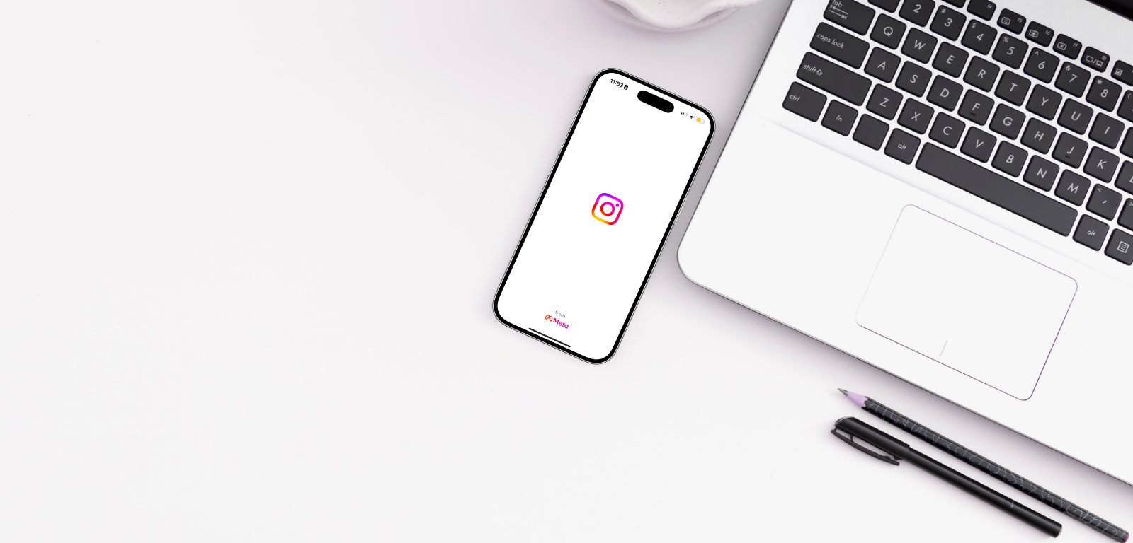 Ett bord uppifrån med en iphone med en bild på Instagram. En del av en dator syns ockspå