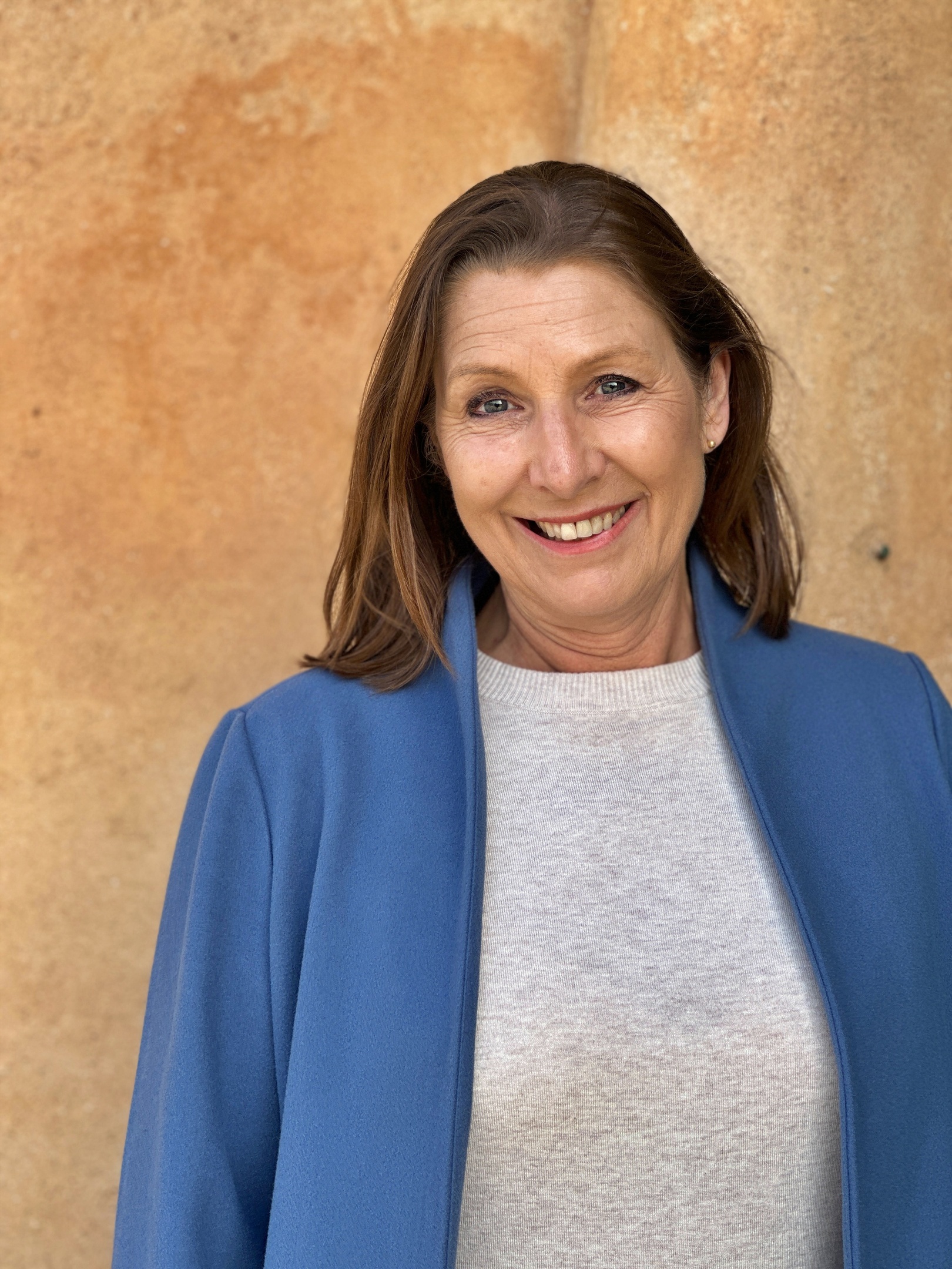 Kvinna som ler med blå kavaj och mörkt hår Inspirationsbolaget AB